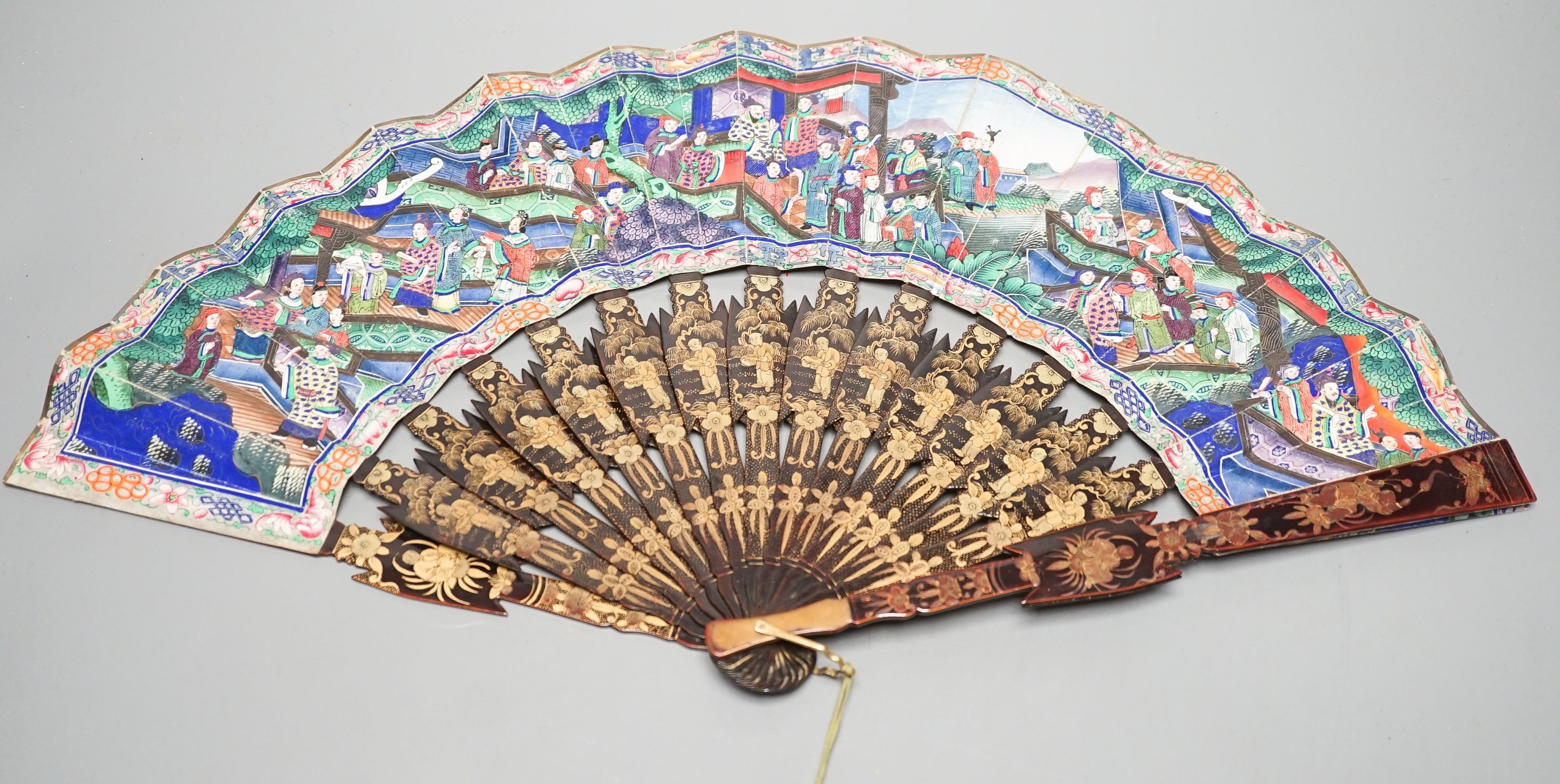 A Chinese export gilt decorated lacquer fan and box, mid 19th century, the appliqué work paper fan leaf decorated with figures amid pavilions and trees, box 32cm